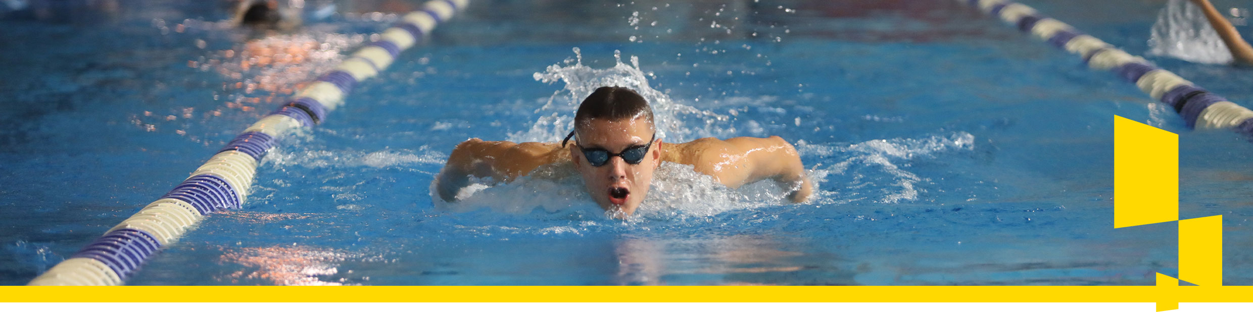 Zdjęcie ukazuje płynącego w basenie młodego chłopaka z okularami pływackimi na oczach.