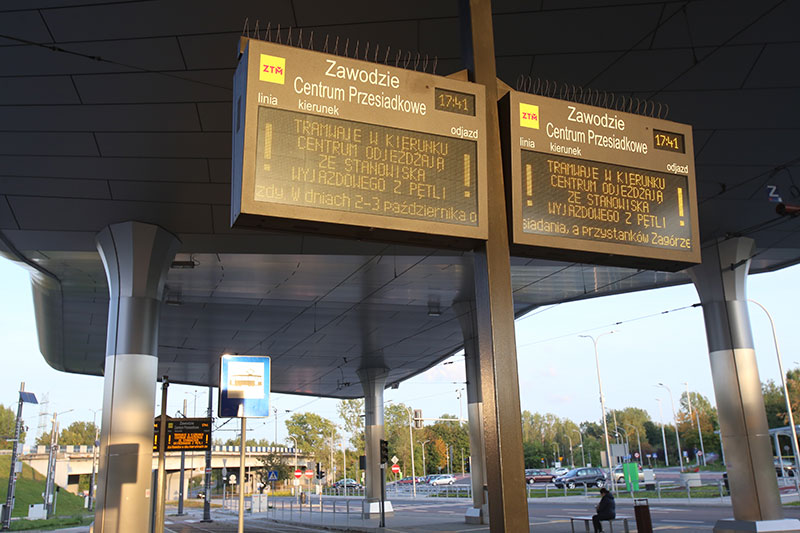 Fotografia przedstawia elektroniczne tablice informacyjne dla pasażerów na węźle przesiadkowym.
