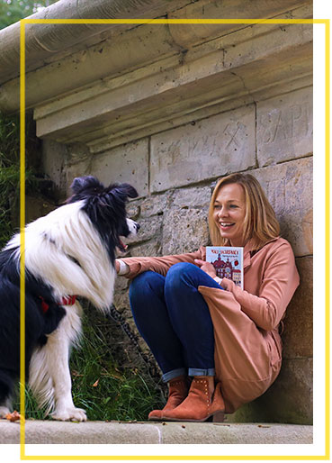 Fotografia przedstawia Agatę Frączek, tarnogórzankę, pisarkę, autorkę książki „Mali skarbnicy i tajemniczy przyjaciel”. Kobieta opiera się w przysiadzie o ścianę wlotu sztolni. W jednej ręce trzyma książkę, drugą głaszcze dużego psa o czarno-białej sierści, siedzącego naprzeciw niej.