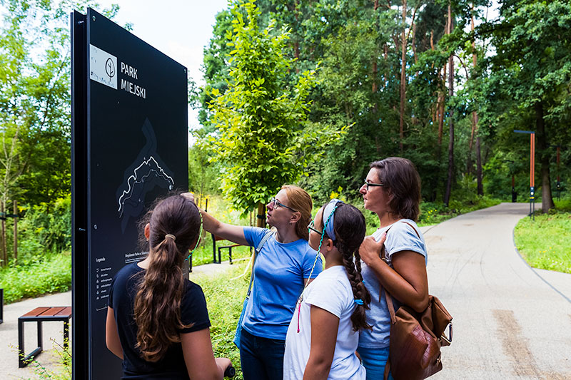 Fotografia przedstawia cztery osoby: dwie kobiety i dwie dziewczynki, które przyglądają się mapie parku.