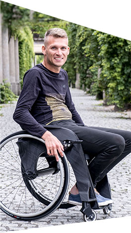 Fotografia przedstawia Rafała Mikołajczyka, na superlekkim wózku inwalidzkim firmy Cosmotech.
