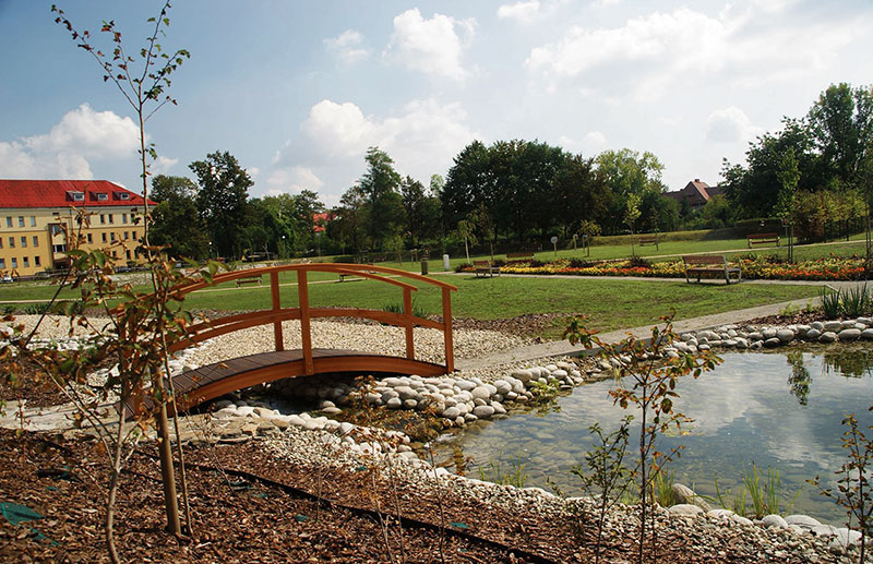 Drewniany mostek przy oczku wodnym w parku